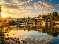 Мости та ріки - Світло і тінь Старовинний міст над рікою у золотому світлі заходу сонця